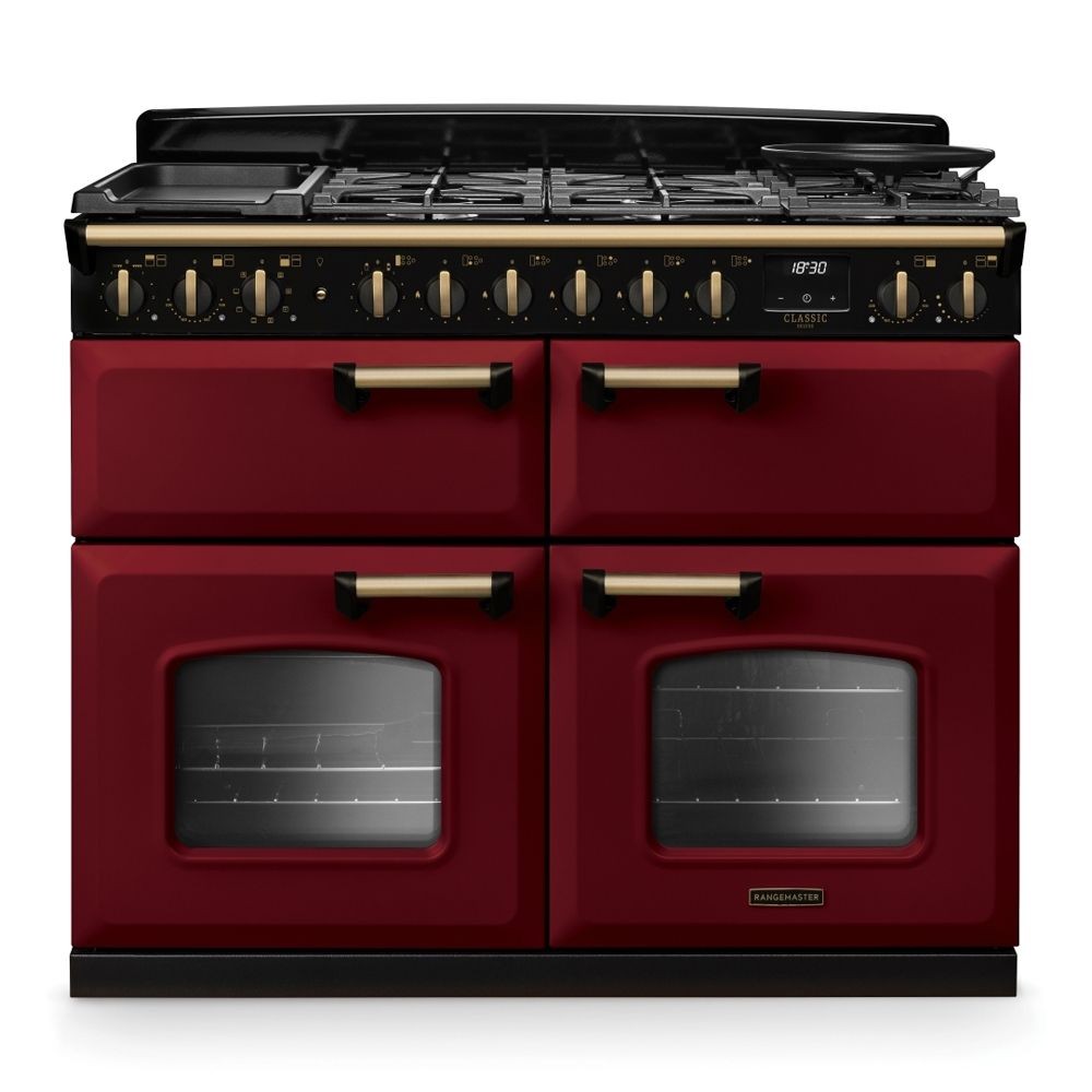 Classic Deluxe 110cm dual fuel range cooker in Bordeaux red and antique brass, featuring four gas burners, two glass-fronted ovens, and stylish control knobs.