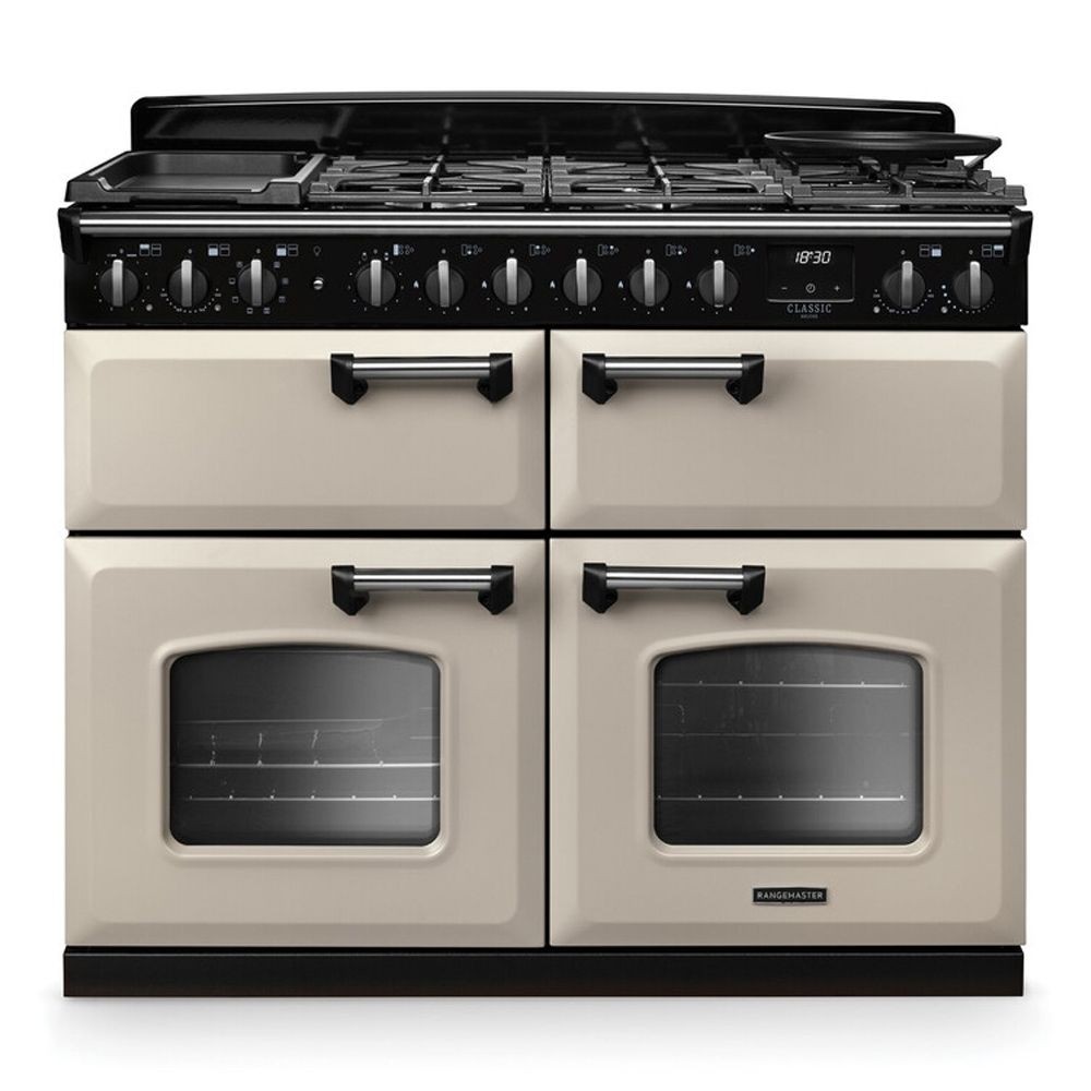 Classic Deluxe 110cm BC dual fuel range cooker in pale cream with chrome accents, featuring four gas burners, two ovens, and a sleek black control panel.