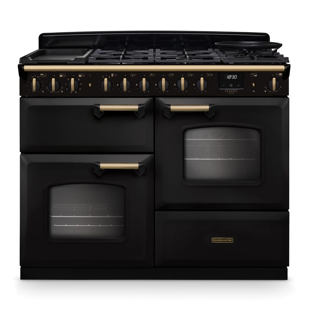 Classic Deluxe 110cm dual fuel range cooker in charcoal black with antique brass accents, featuring multiple burners, a griddle, and two large ovens with glass doors.