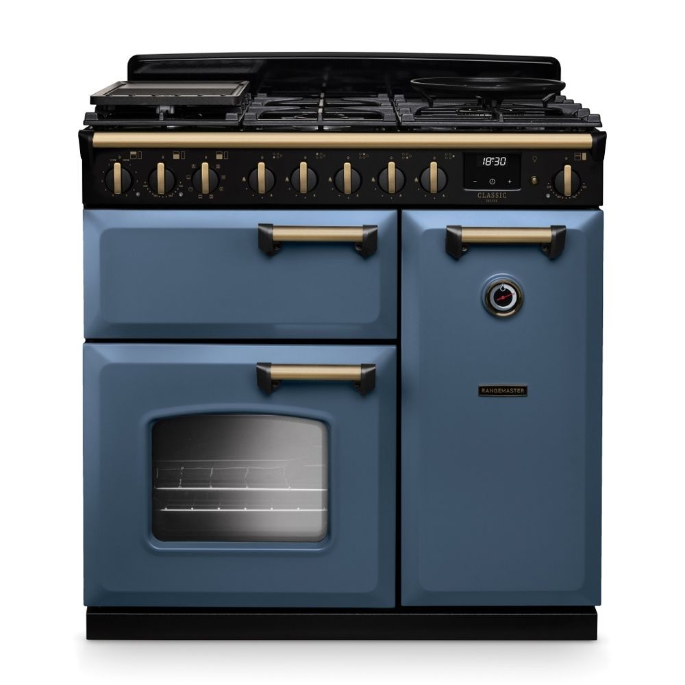 Classic Deluxe 90cm dual fuel range cooker in stone blue with antique brass accents, featuring a black gas hob, multiple control knobs, and a large oven with a glass door.