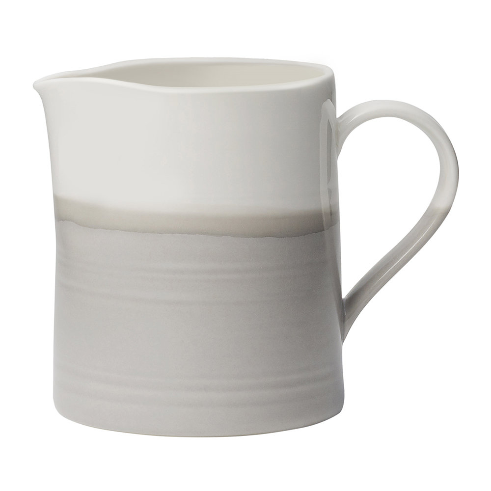 Ceramic milk frothing jug in white and soft gray with a smooth finish, featuring a curved spout and a comfortable handle, ideal for coffee preparation.