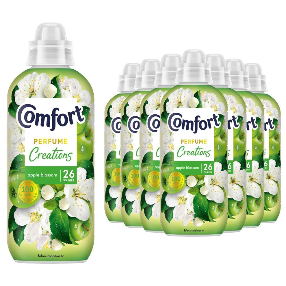 Green plastic bottles of Comfort Creations Apple Blossom Fabric Conditioner, each 780ml, featuring white apple blossom flowers and leaves, labeled for 26 washes, arranged in a group.