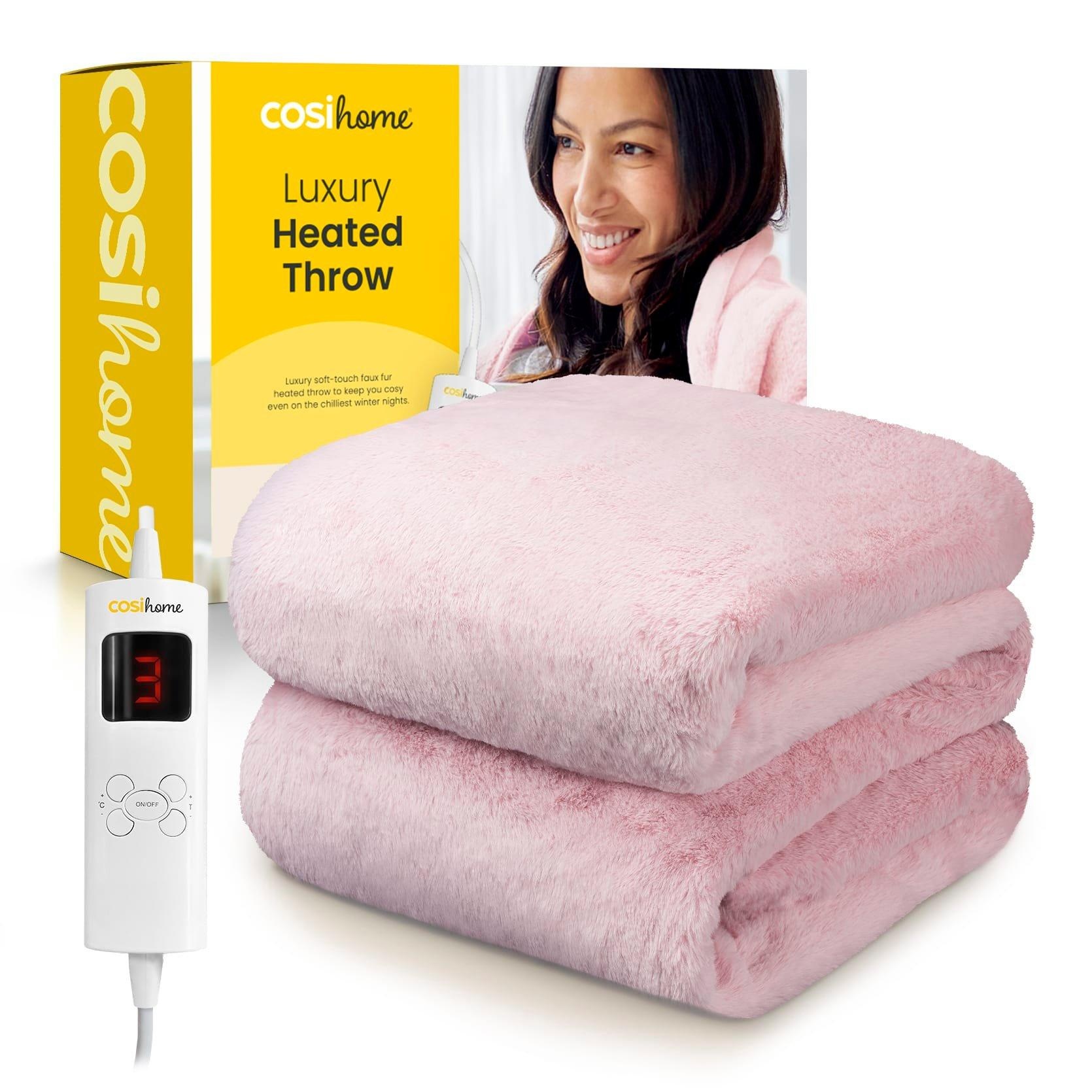 Soft pink faux fur heated throw blanket from Cosi Home, featuring a white control unit with a digital display for temperature settings, packaged in a bright yellow box.