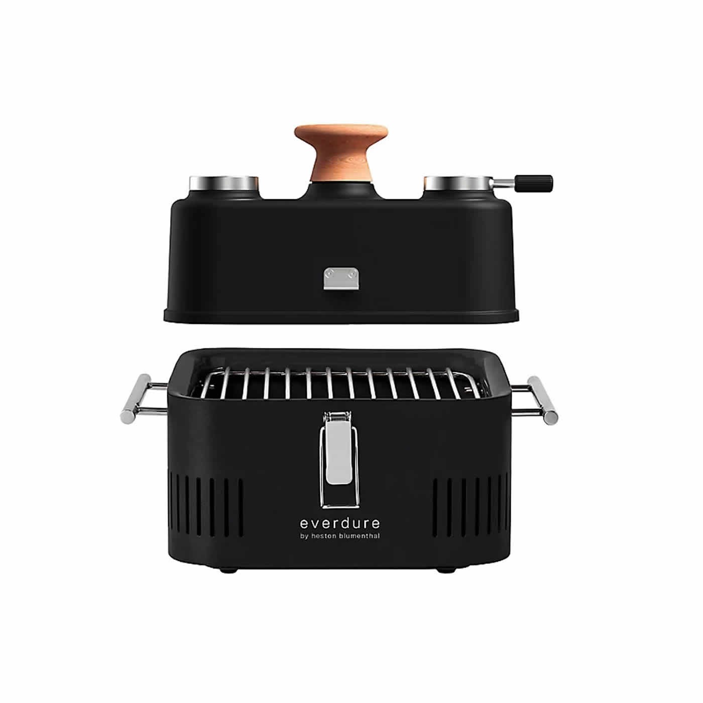 Black portable grill with a wooden handle, featuring a sleek design, stainless steel accents, and a removable grilling tray, labeled "everdure by heston blumenthal."