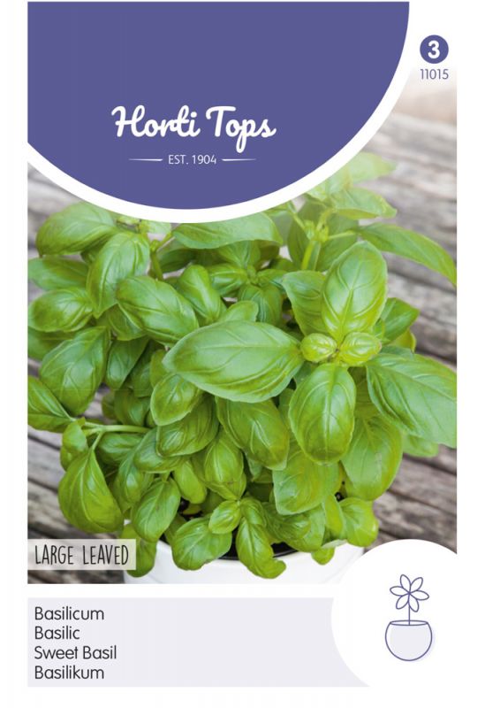 Green basil plant with large, glossy leaves on a wooden surface, featuring a white and purple packaging label with the text "Horti Tops" and product details.