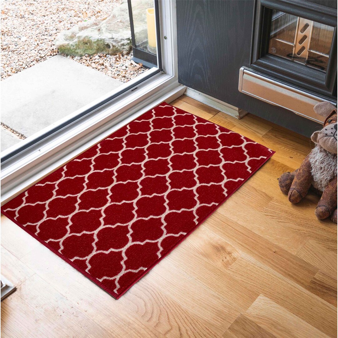 Red anti-slip doormat featuring a trellis pattern in cream, measuring 120x160 cm, placed at an entryway with wooden flooring and a cozy atmosphere.