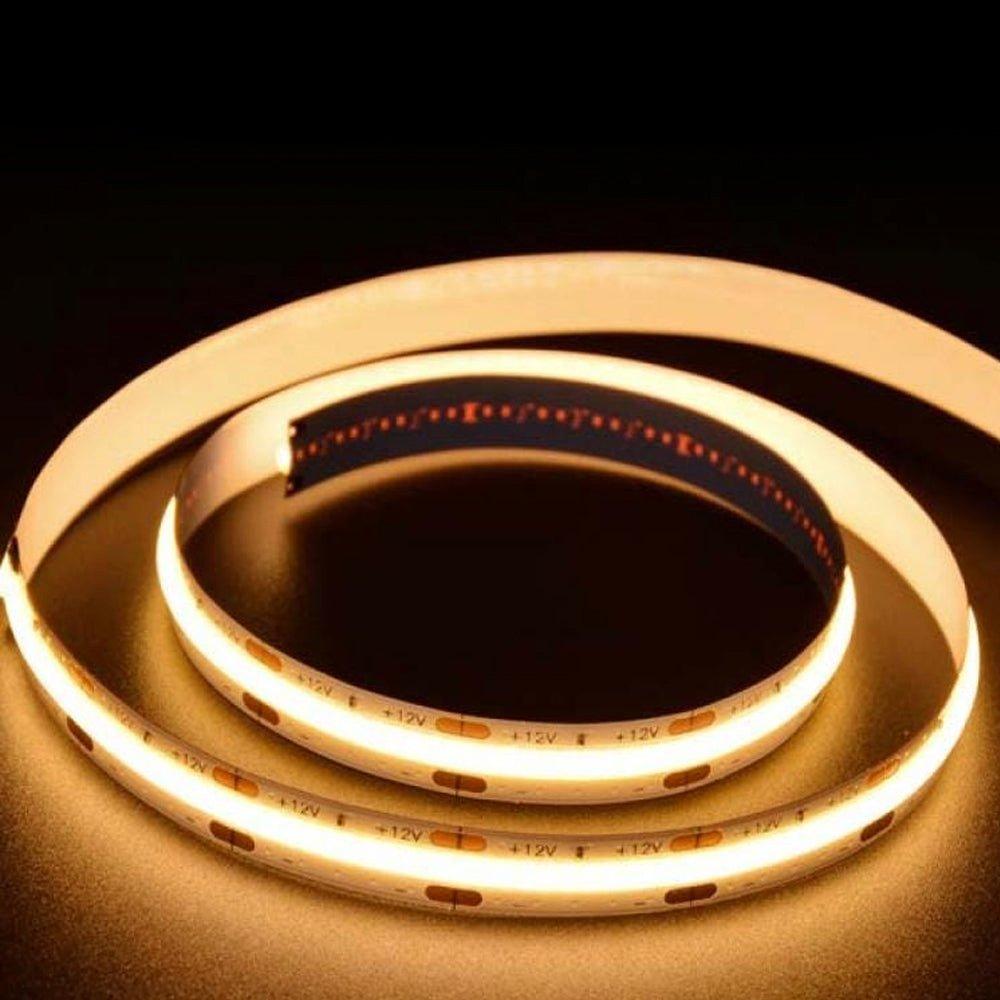 Flexible 12V COB LED strip lights in warm white (3000K), featuring 300 LEDs per meter, 10W per meter, and a high CRI of 90-92, coiled on a dark background.