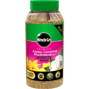 Clear plastic container with a green cap, featuring a pink label that reads "Miracle-Gro Azalea, Camellia & Rhododendron Continuous Release Plant Food" with floral images.