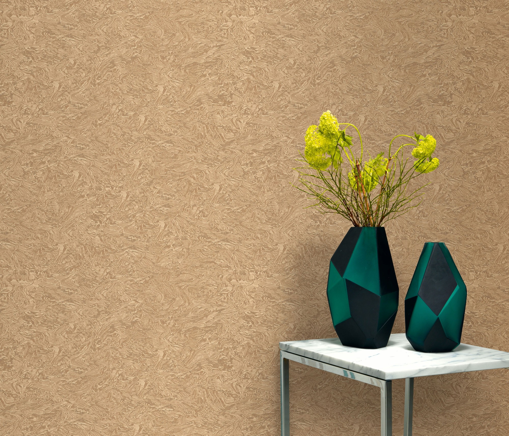 Gold marble-effect wallpaper with a glossy finish, featuring a textured design, complemented by two geometric vases in dark teal and a bouquet of yellow flowers on a marble-topped table.