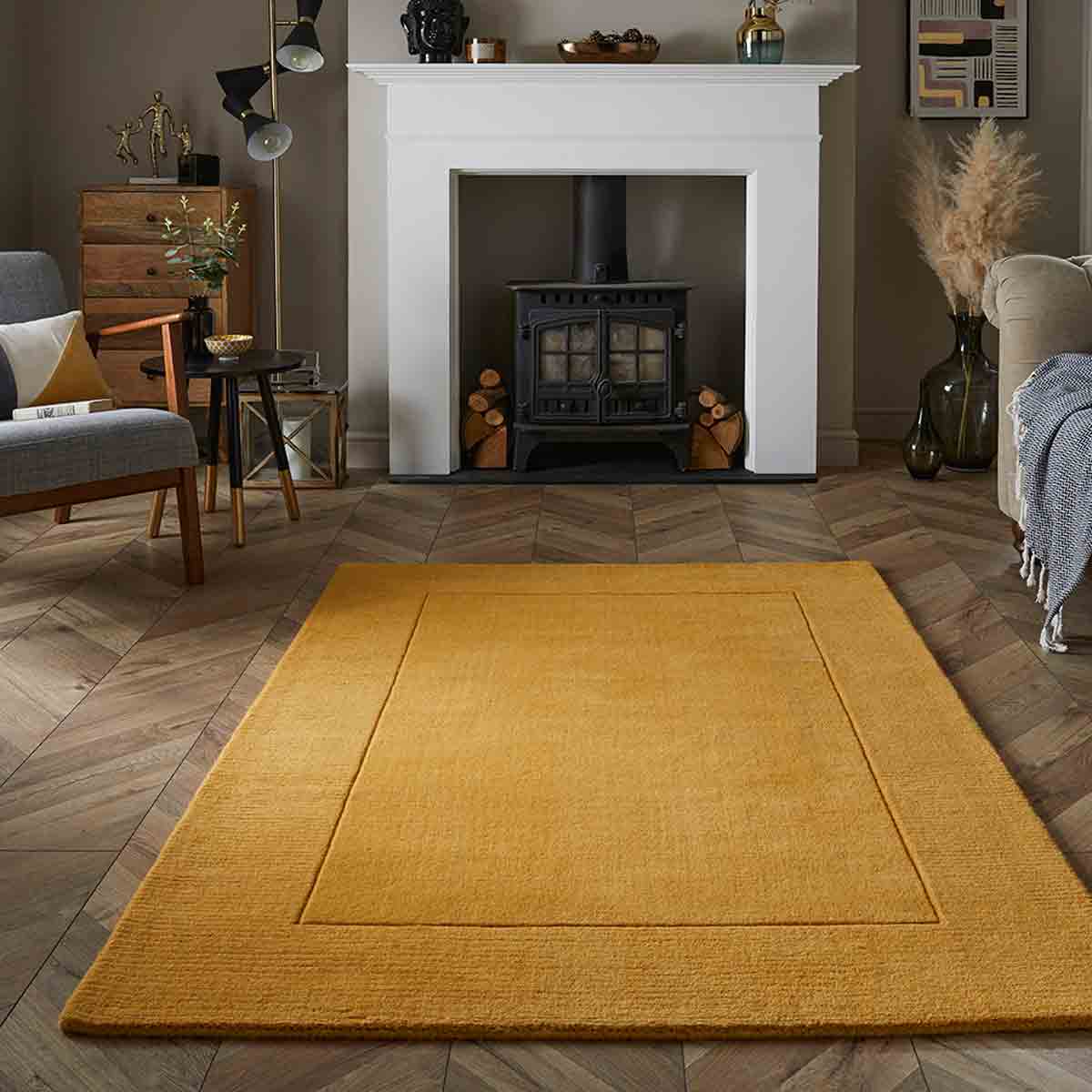Ochre yellow wool rug measuring 120x170cm, featuring a simple rectangular design, placed on a wooden floor in a cozy living room setting.