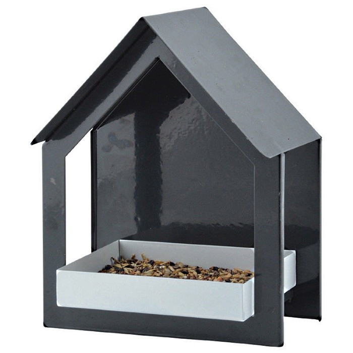 Black metal wall bird feeder with a house-shaped design, featuring a sloped roof and a white feeding tray filled with birdseed.