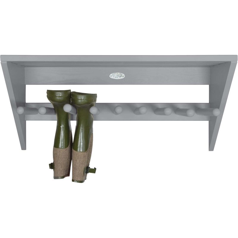 Gray wooden wall-mounted boot rack featuring a slanted top, six round pegs for hanging, and two green boots with burlap accents displayed below.