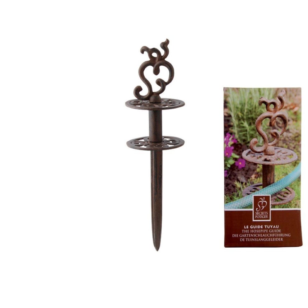 Rusted metal hose guide with decorative scroll design, featuring two circular platforms and a pointed stake for securing in the ground, accompanied by branded packaging.