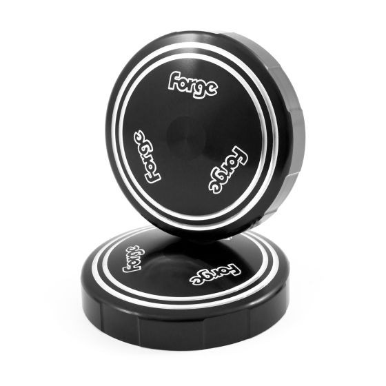 Black Forge Strut Top Covers featuring a sleek, round design with white branding, made from durable material, ideal for automotive applications.