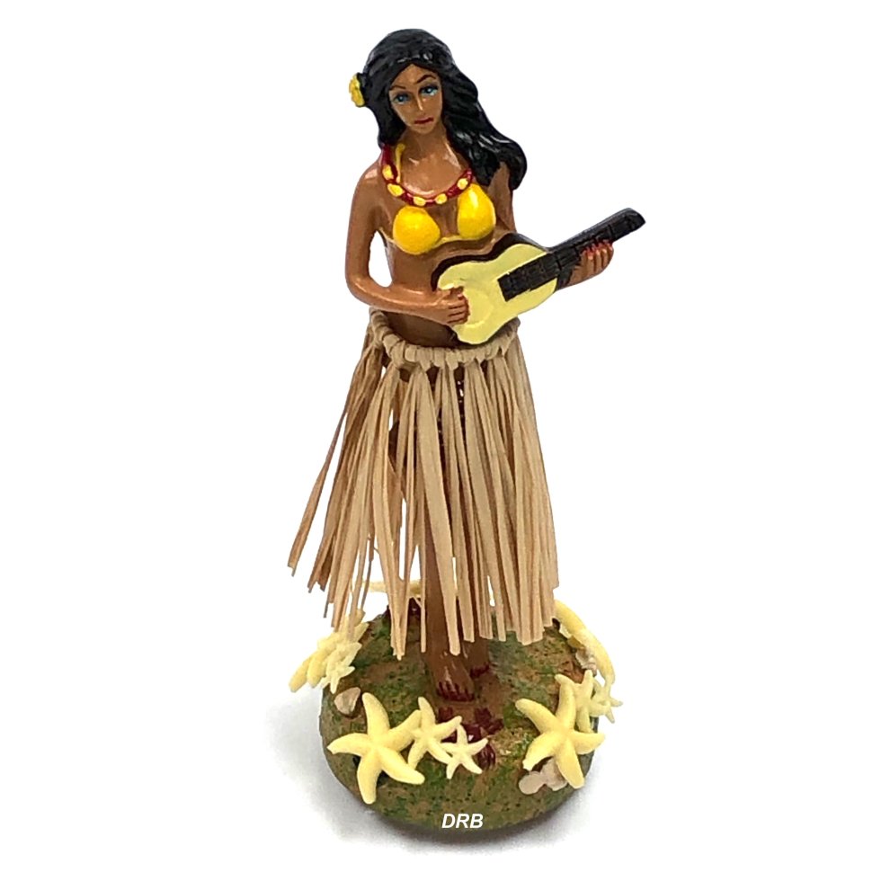 Tropical hula girl air freshener features a brown-skinned figure in a yellow bikini top, grass skirt, holding a guitar, surrounded by yellow starfish on a green base.