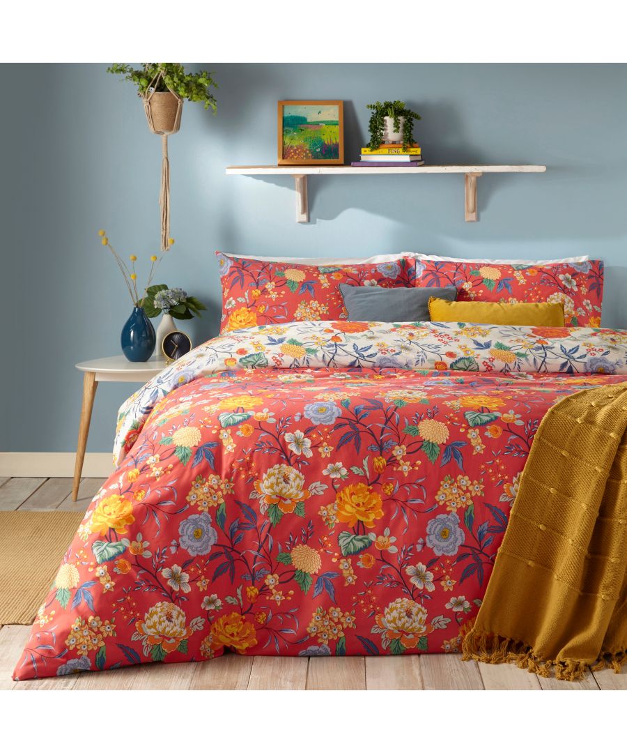 Red cotton duvet cover set featuring a vibrant floral pattern with yellow and blue accents, paired with matching pillowcases, styled in a cozy bedroom setting.