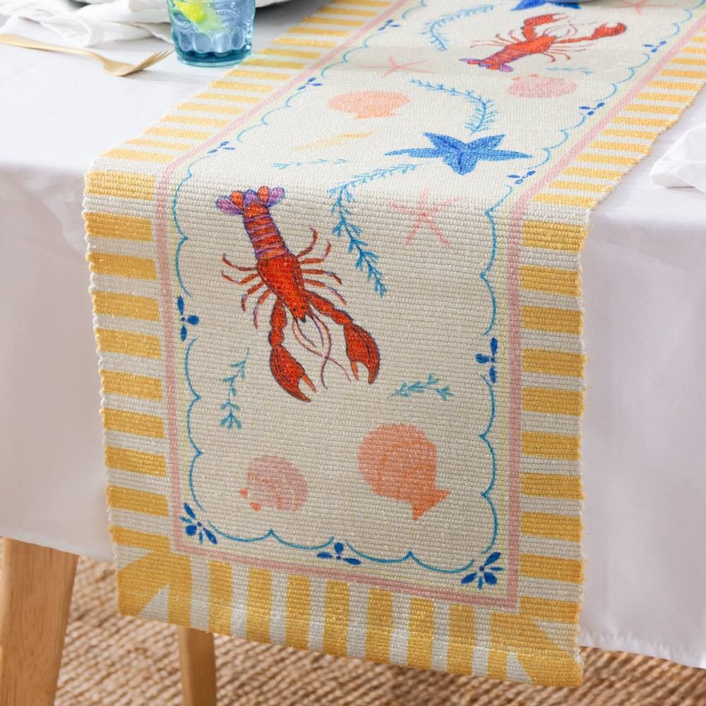 Brightly colored table runner featuring lobster and shell motifs on a cream background, bordered with yellow stripes, made from durable material suitable for indoor and outdoor use.