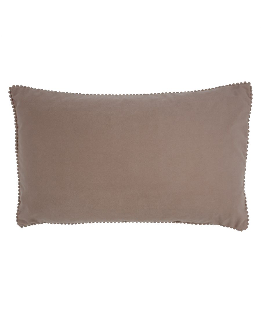 Soft velvet cushion in a warm taupe color, featuring a smooth texture and trimmed with small, round pom poms along the edges for added detail.