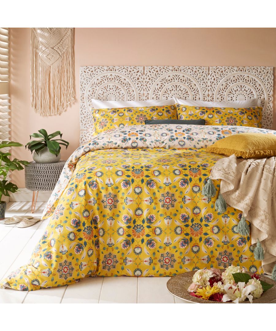 Yellow cotton duvet cover set featuring floral patterns, complemented by matching pillowcases, styled with a textured throw and decorative plants in a cozy bedroom setting.