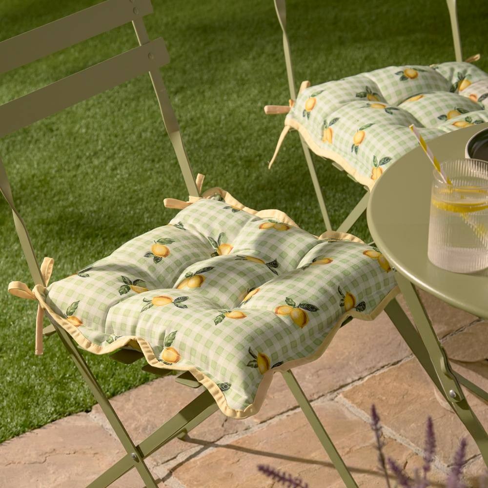 Green gingham seat pads featuring lemon prints, designed for indoor or outdoor use, with tufted cushions and ties for secure attachment, sold as a two-pack.