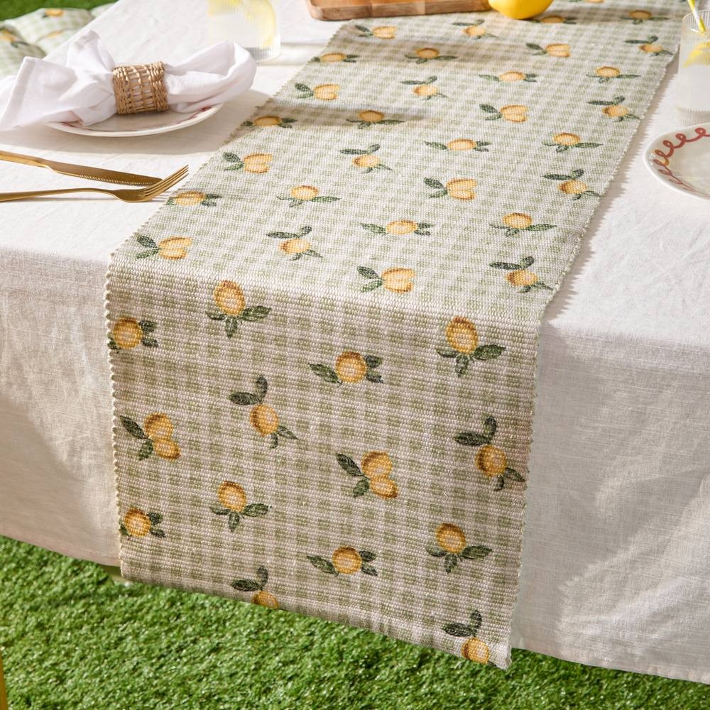 Yellow table runner featuring a lemon pattern on a green and white checkered background, measuring 220 x 35 cm, suitable for indoor or outdoor use.