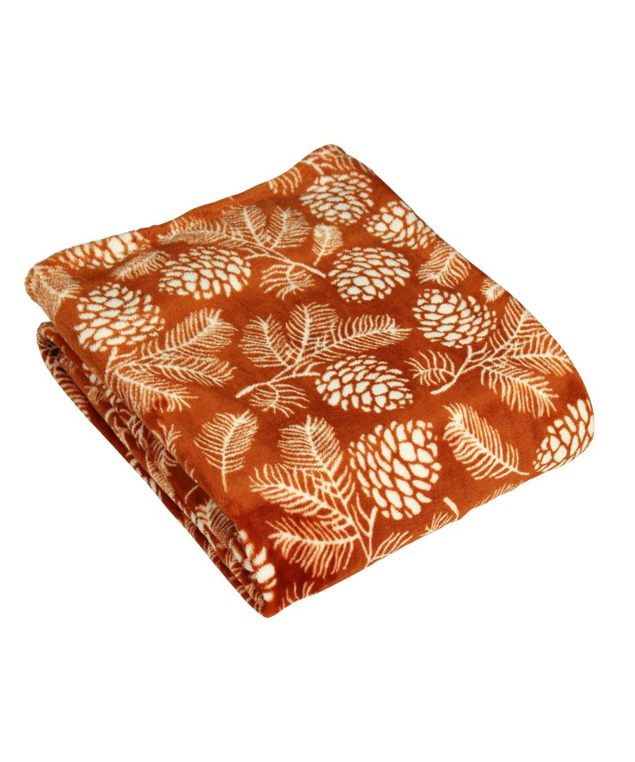 Rust-colored throw blanket featuring a soft, plush texture with a botanical pattern of white pinecones and leaves, measuring 140 cm x 180 cm.