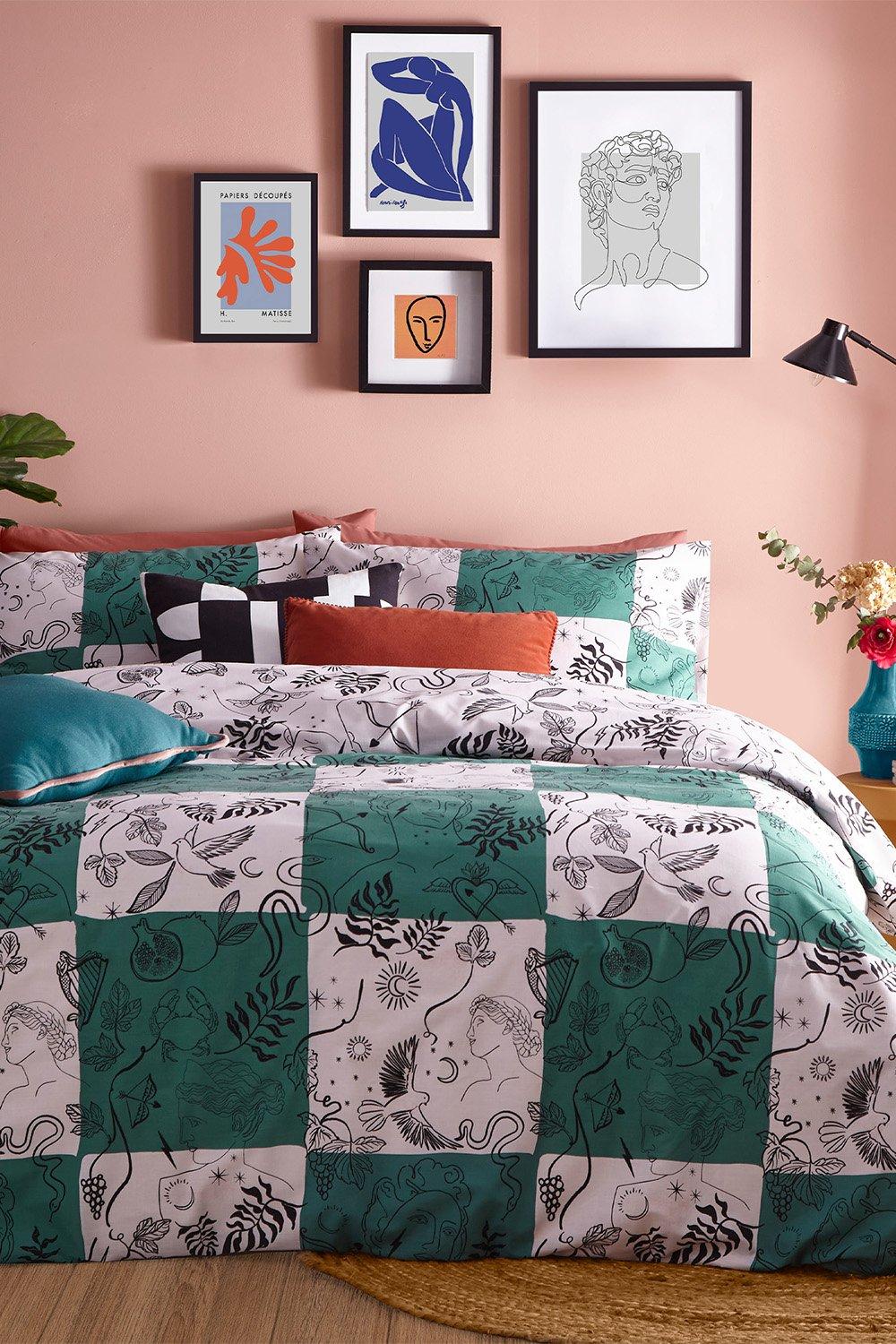 Reversible duvet cover set featuring a green and white checkerboard pattern with black line drawings of plants and animals, complemented by colorful accent pillows and wall art.