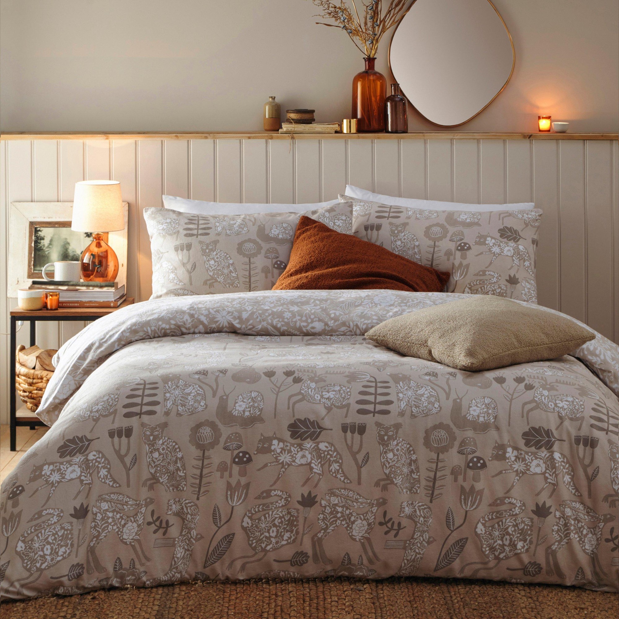 Beige duvet set made from 100% brushed cotton, featuring a floral and animal print, complemented by matching pillowcases and decorative cushions on a textured bedspread.