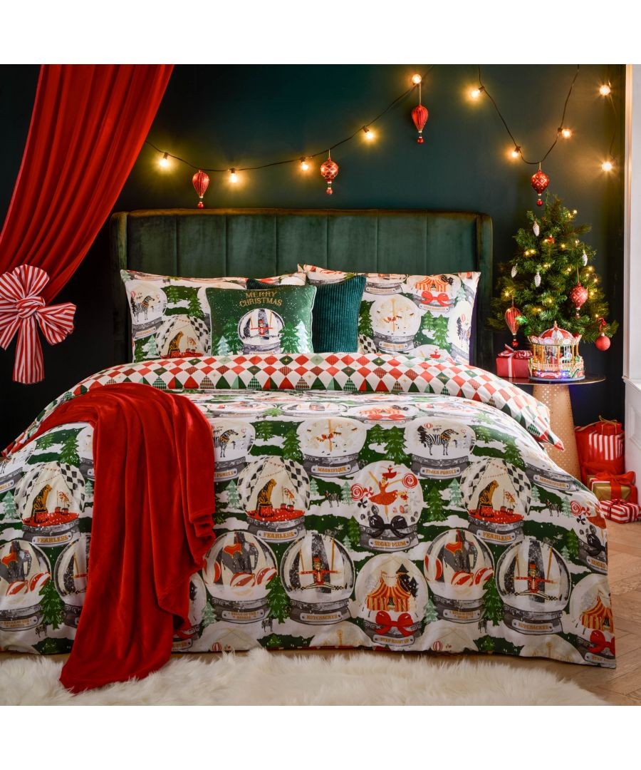 Festive green polycotton duvet cover set featuring colorful circus-themed prints, complemented by a red throw, decorative pillows, and a Christmas tree in a cozy setting.