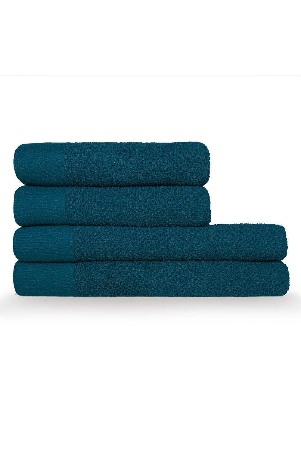 Four stacked towels in a rich teal color, featuring a textured weave design with a smooth cotton finish and plush terry edges, ideal for hand and bath use.