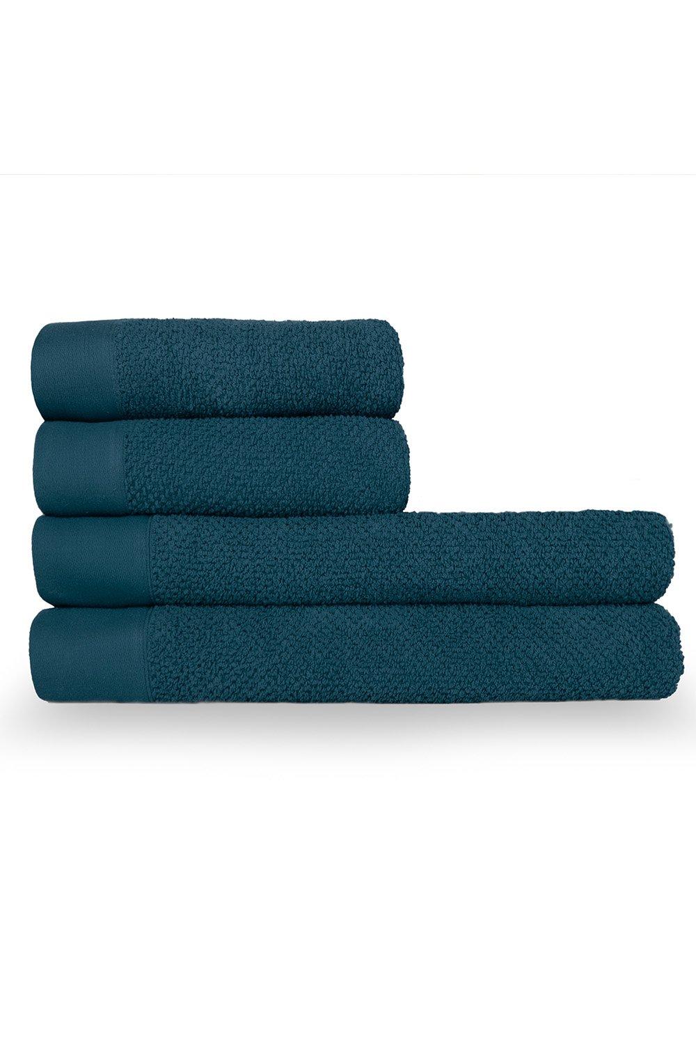 Four textured weave cotton towels in a deep teal color, featuring a smooth border and plush terry fabric, stacked neatly for display.