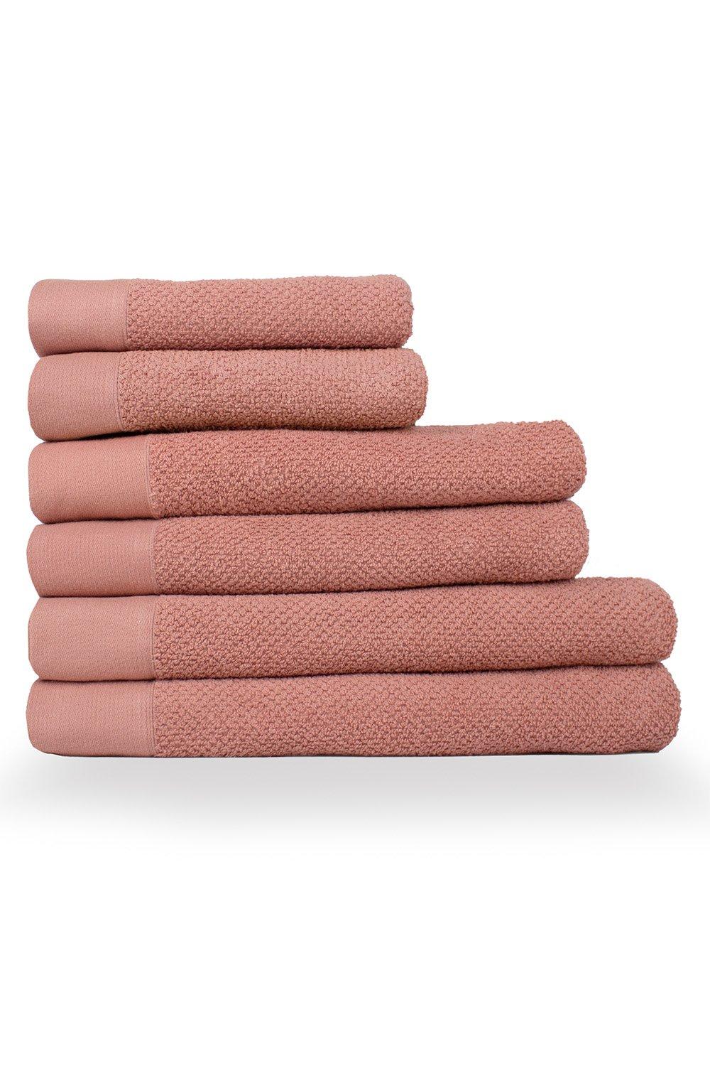Soft, textured weave towels in a warm blush pink, featuring a mix of smooth and terry cotton materials, neatly stacked in a 6-piece set for hand, bath, and sheet use.