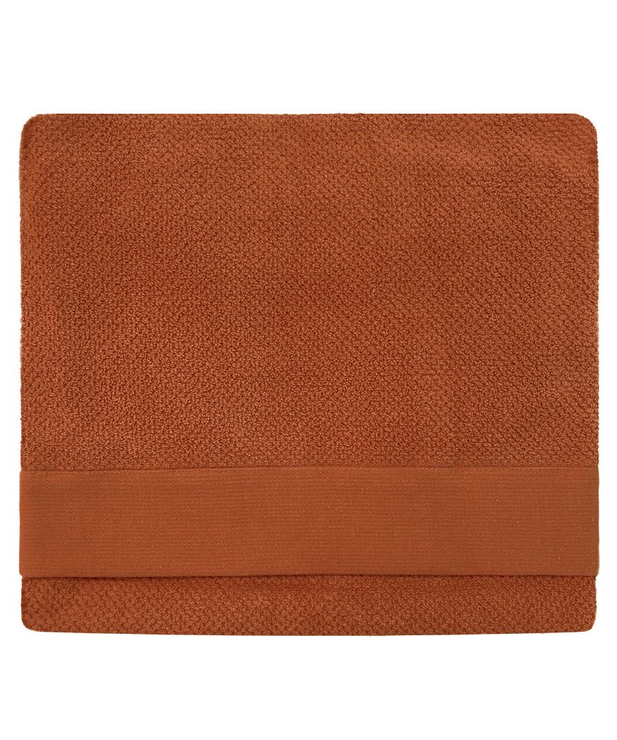 Textured brown cotton bath sheet with a soft, woven surface and a solid band along one edge, designed for comfort and absorbency.