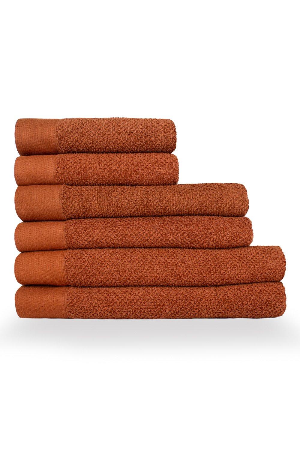 Set of six textured weave cotton towels in a warm terracotta color, featuring a soft, plush surface and smooth borders for a stylish and functional bathroom accessory.