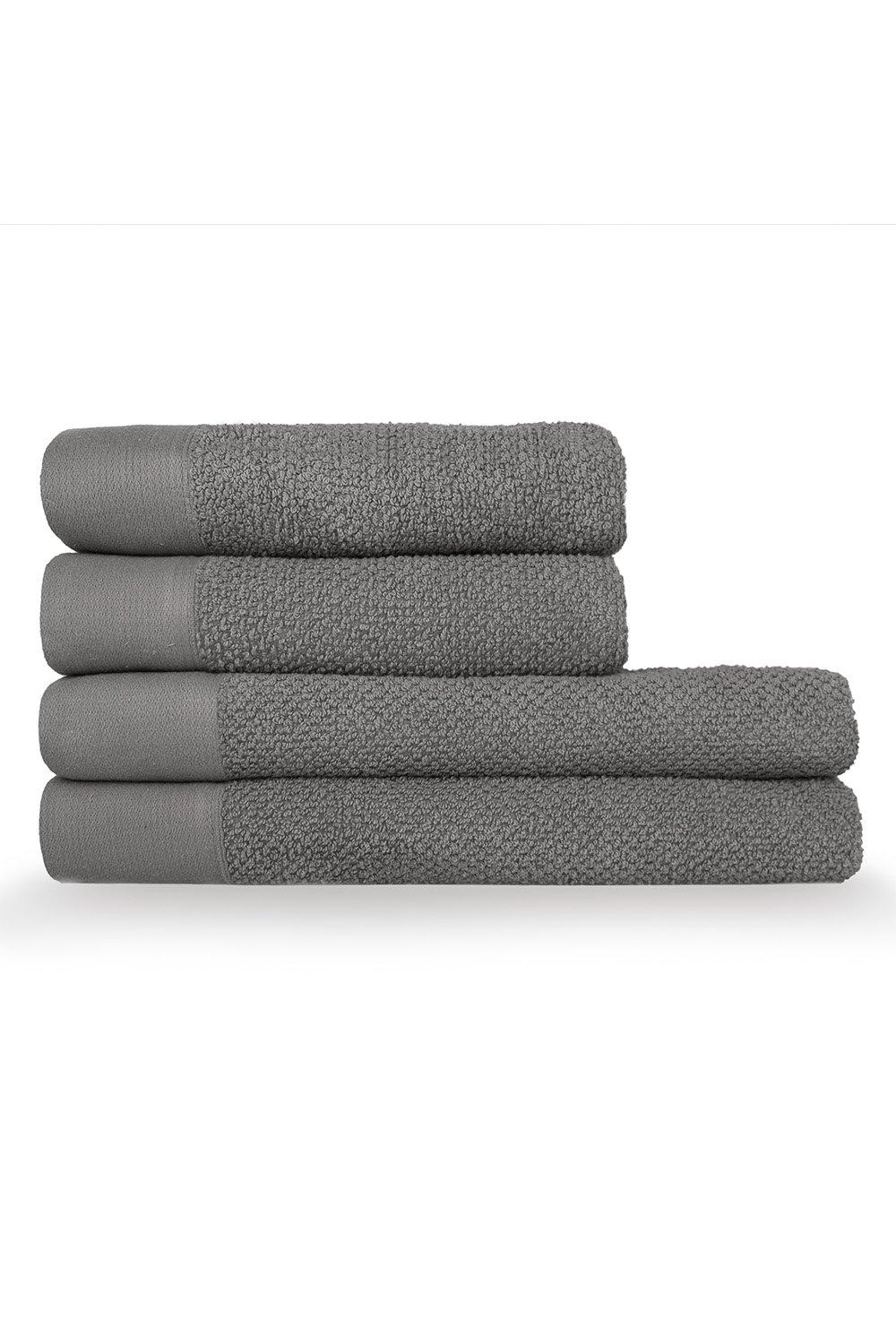 Four stacked towels in varying textures, featuring a soft, textured weave in a muted gray color, with a smooth cotton panel at the bottom of each towel.