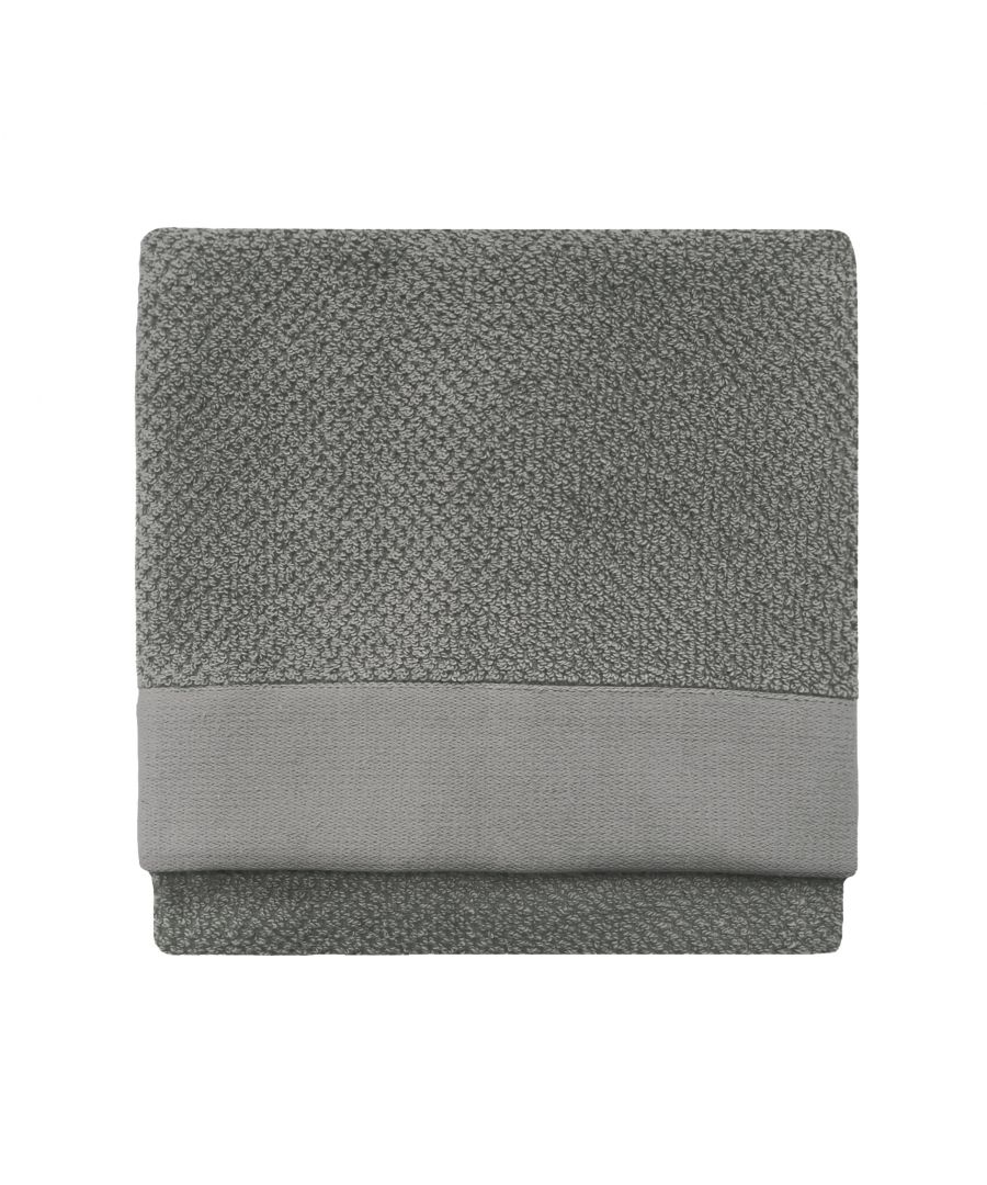 Textured grey cotton hand towel featuring a woven design and a smooth grey band at the bottom, folded neatly for display.