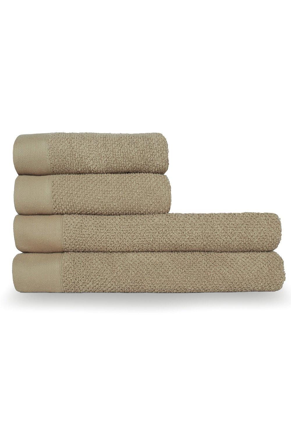 Four stacked cotton towels in a textured weave, featuring a soft beige color with a smooth border, designed for hand and bath use.