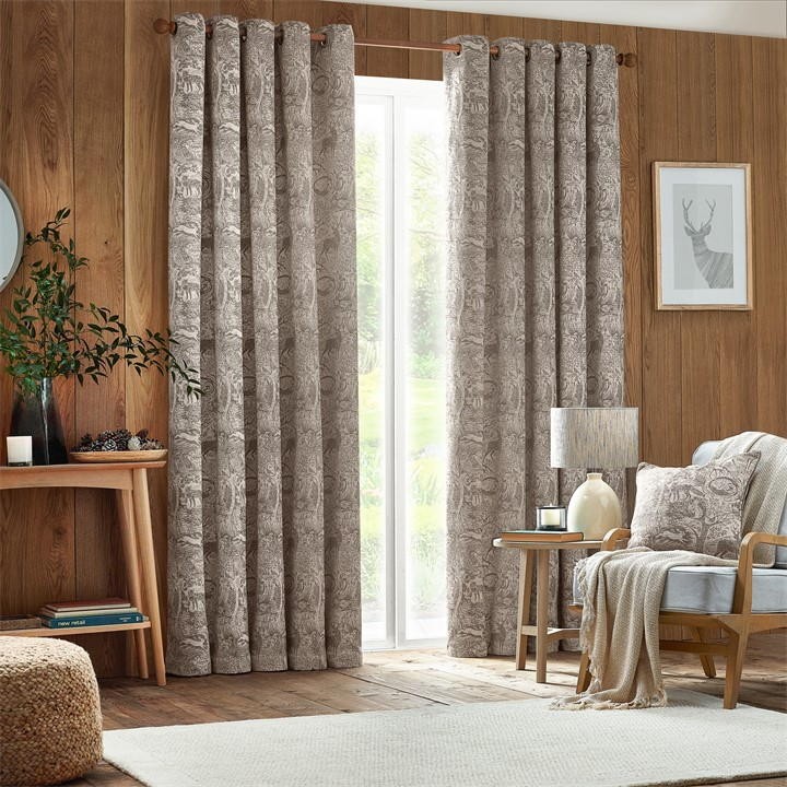 Taupe chenille eyelet curtains featuring a winter woods animal print, measuring 168cm wide by 183cm drop, elegantly draping in a cozy, wooden interior setting.