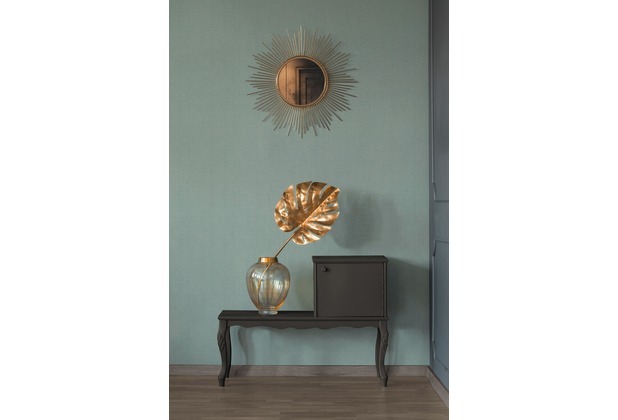 Hessian effect texture wallpaper in beige and green with metallic accents, complementing a stylish interior featuring a sunburst mirror and decorative vase.