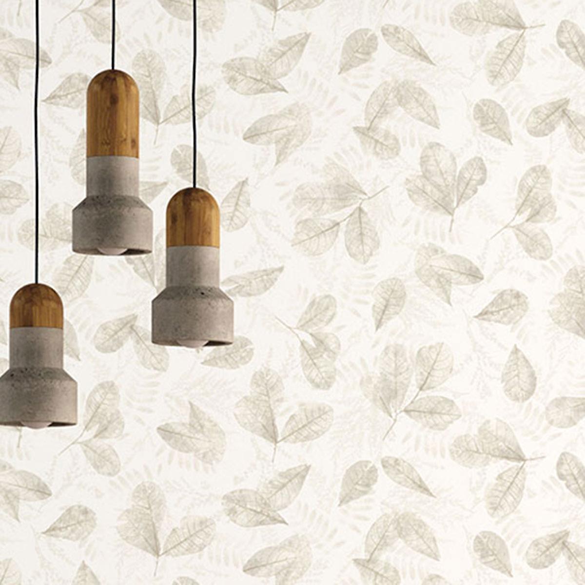 Light beige wallpaper featuring a delicate fossil leaf pattern in various shades, complemented by three pendant lights with wooden and concrete finishes.