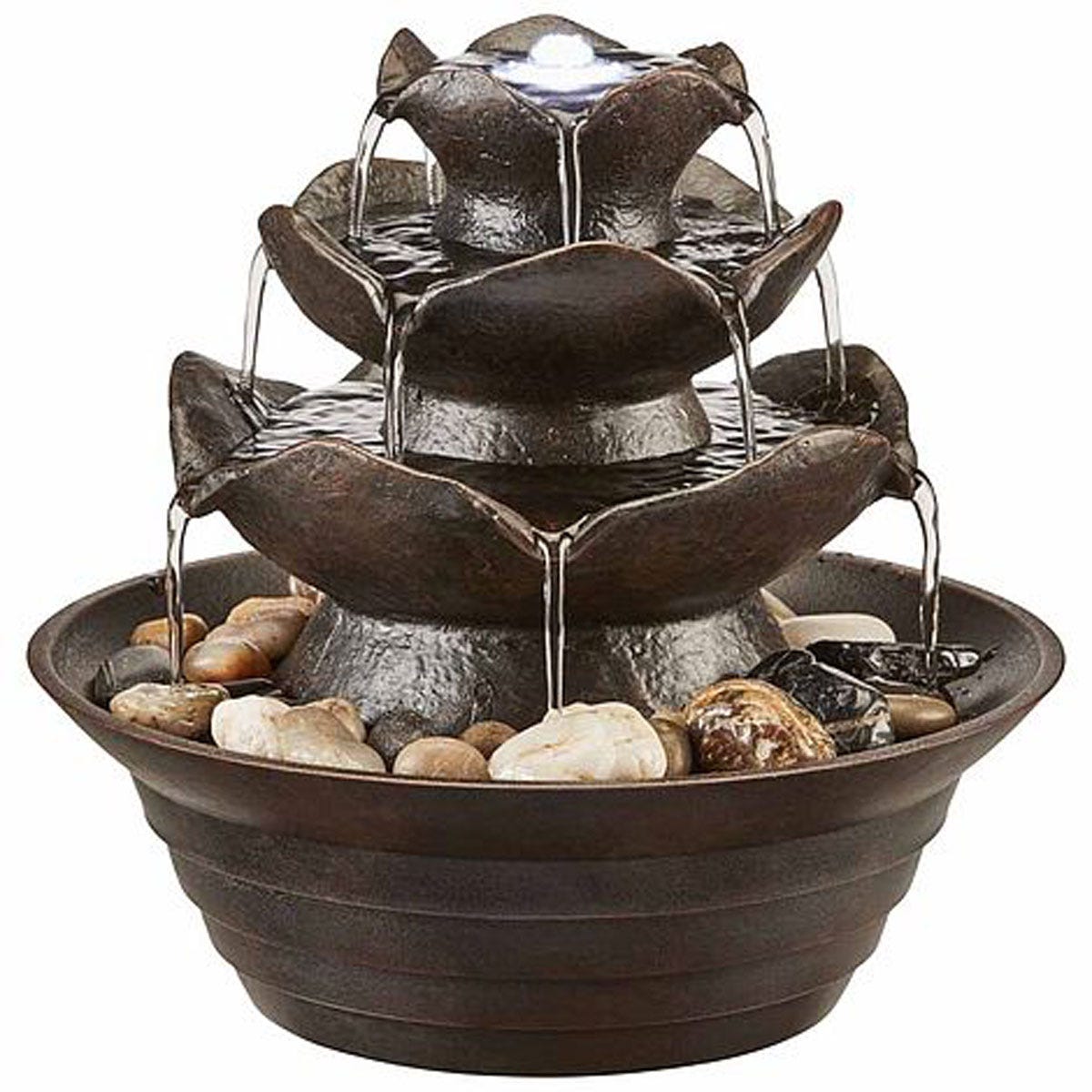 A tiered water feature with a dark brown finish, featuring flower-shaped layers, cascading water, and decorative pebbles in a circular base.