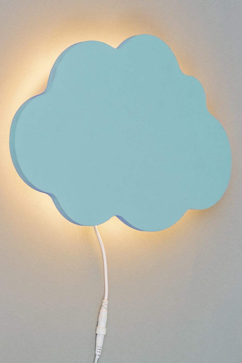 Blue cloud-shaped wall light with a soft glow, made of a smooth material, featuring a visible power cord on a light gray background.