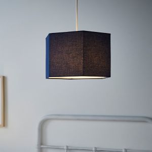 Navy hexagon-shaped light shade made of textured fabric, featuring a simple design and warm interior light, suspended from a white cord in a modern setting.