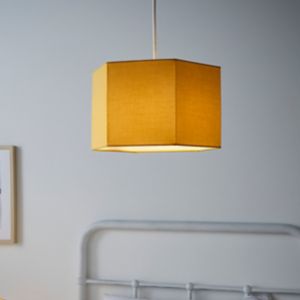 Yellow hexagon light shade made of fabric, featuring a simple design with a warm glow, hanging from a white cord in a softly lit room.