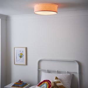 Pink fabric flush ceiling light with a round shape, soft glow, and a simple design, mounted in a cozy bedroom setting with a white wall and colorful decor.