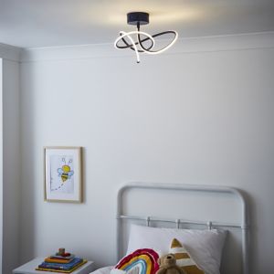 BHS Lighting Glow Whirly Flush Ceiling Light features a modern design with a blue base and white swirling LED accents, illuminating a cozy bedroom space.