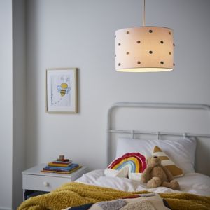 Natural fabric light shade with polka dots, 30cm diameter, hanging from a ceiling in a cozy bedroom setting with a bed, colorful blankets, and a framed bee illustration.