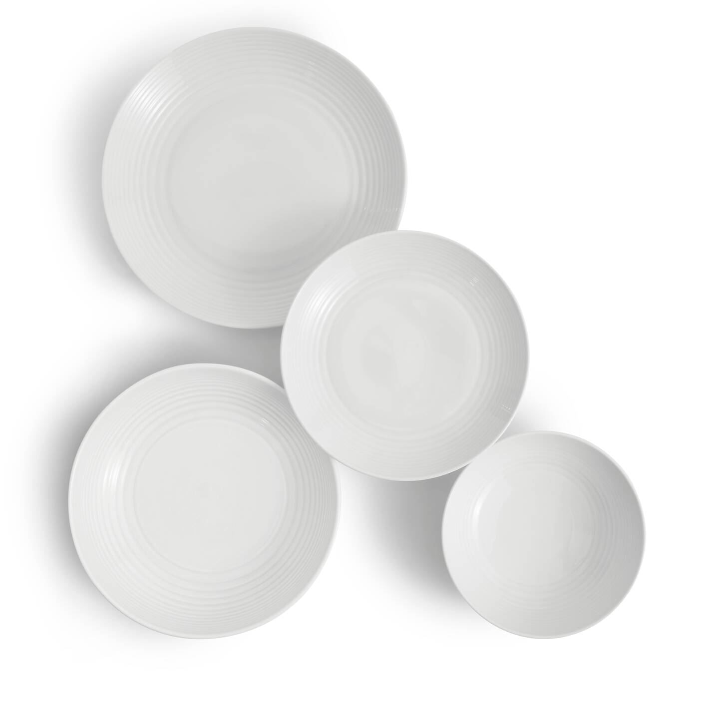 White porcelain dinner set featuring a subtle ribbed design, including four varying sizes of plates and a pasta bowl, all showcasing a sleek, modern aesthetic.