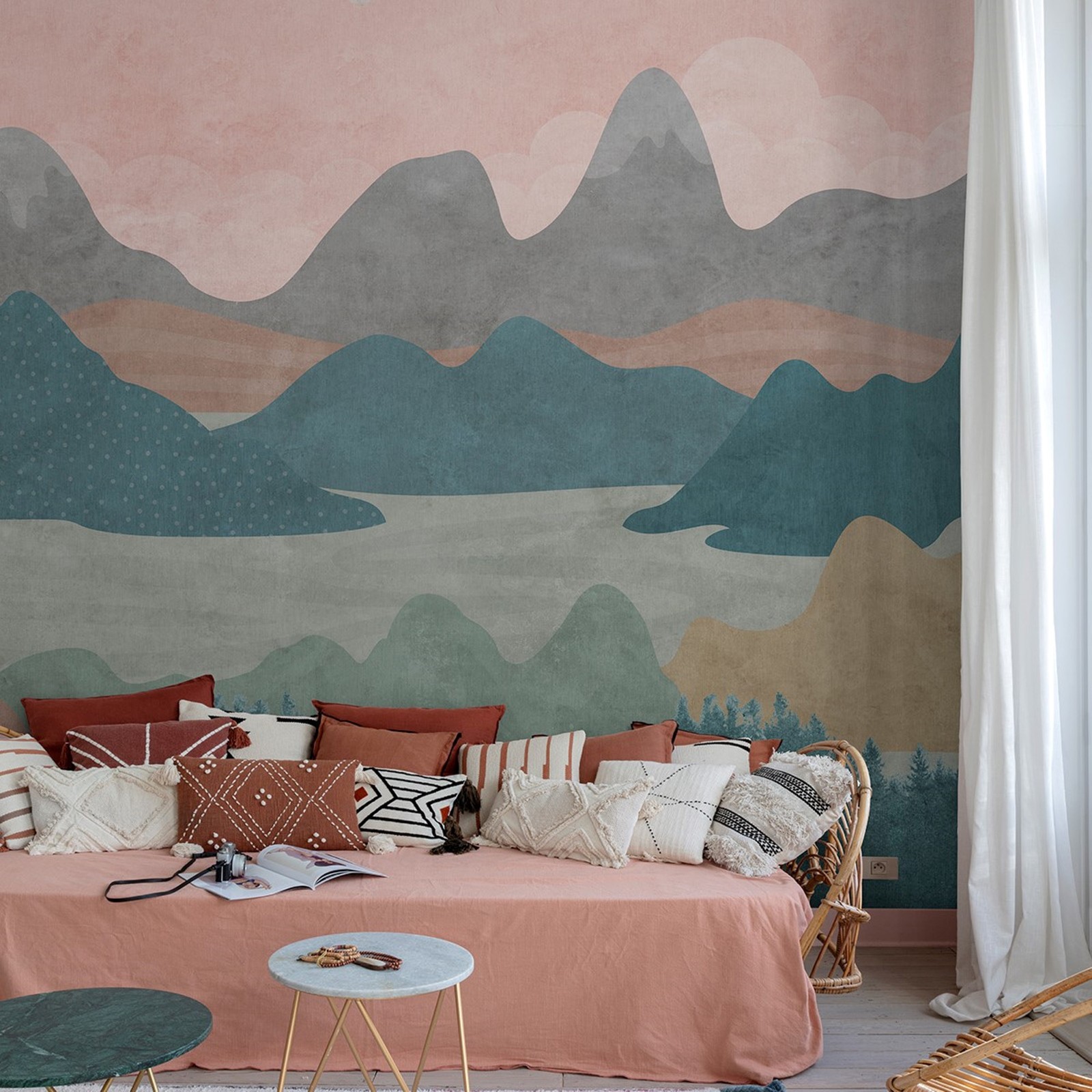 Textured mural featuring a pink and teal landscape with hills and mountains, complemented by earthy tones, set against a cozy living room with decorative cushions and tables.