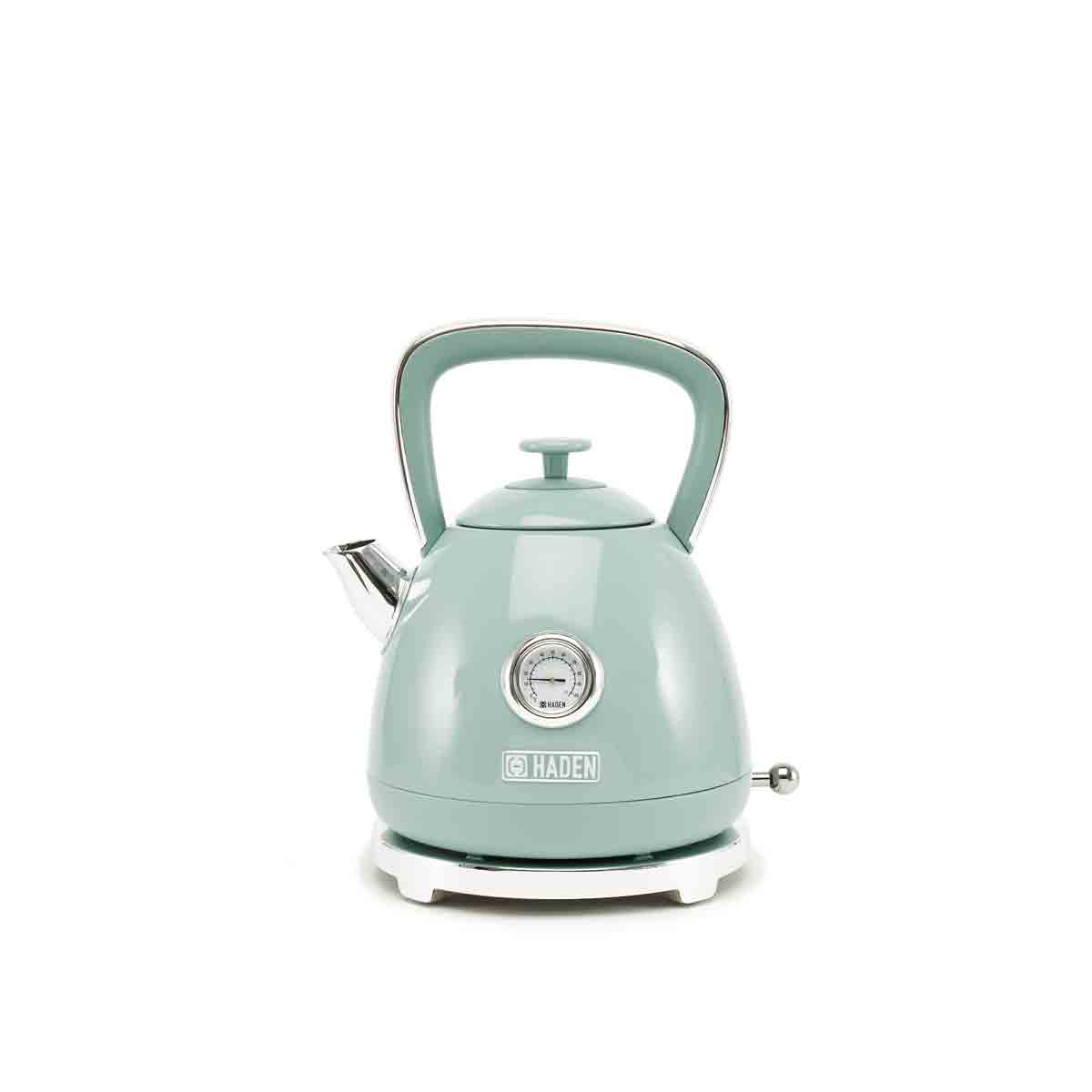 Sage green, retro-style kettle with a rounded body, stainless steel spout, and a temperature gauge on the front, featuring a white base and a comfortable handle.